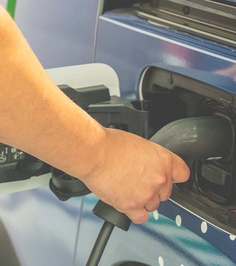 Empleado de la compañía cargando vehículo eléctrico